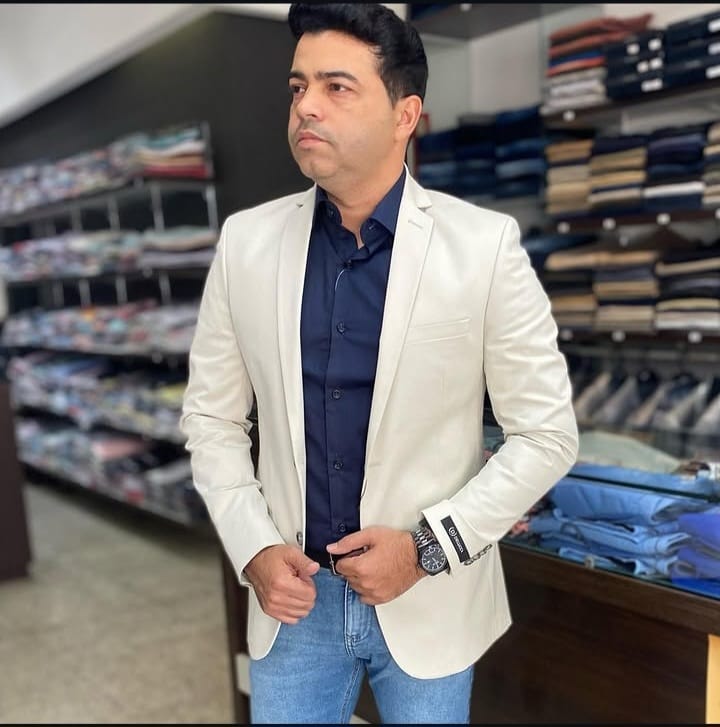 Look masculino Via Men com blazer claro, camisa azul e jeans